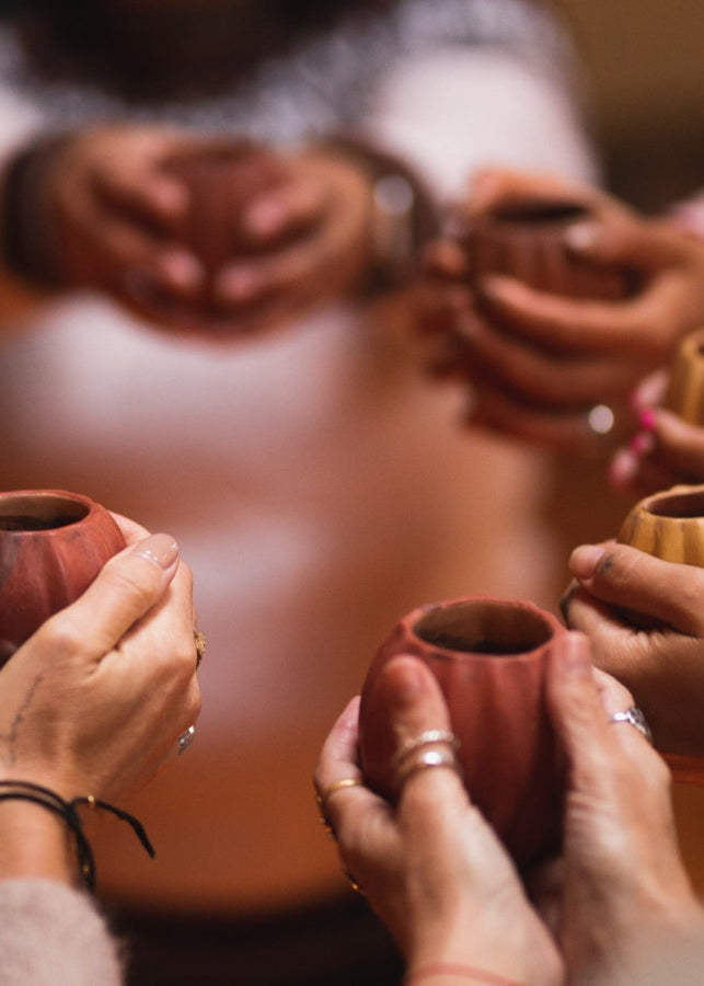 Women holding cups of ceremonial cacao